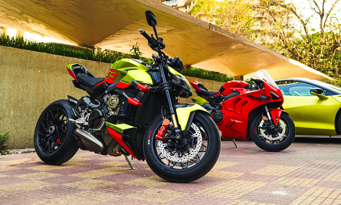 Dos vibrantes motocicletas Ducati aparcadas bajo una marquesina moderna sobre un pavimento urbano.